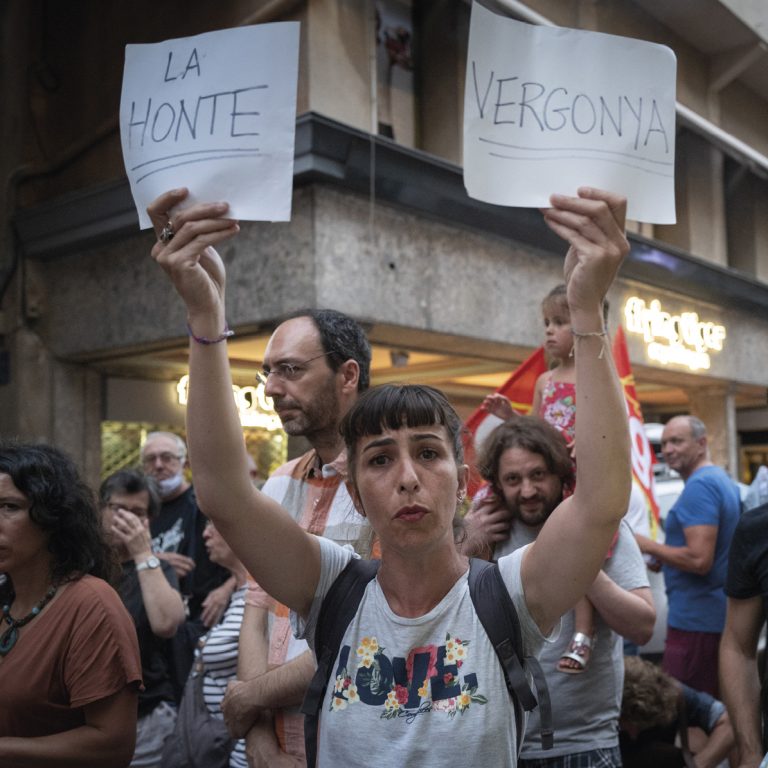 femme en anifestation brandisasnt une pancarte à chaquemain : "la honte" et "vergonya"