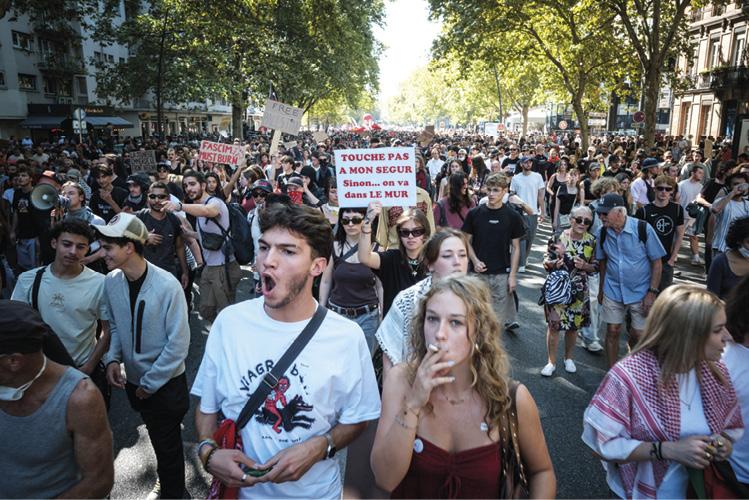 Foule en manif. Jeune fume une cigarette au premier plan