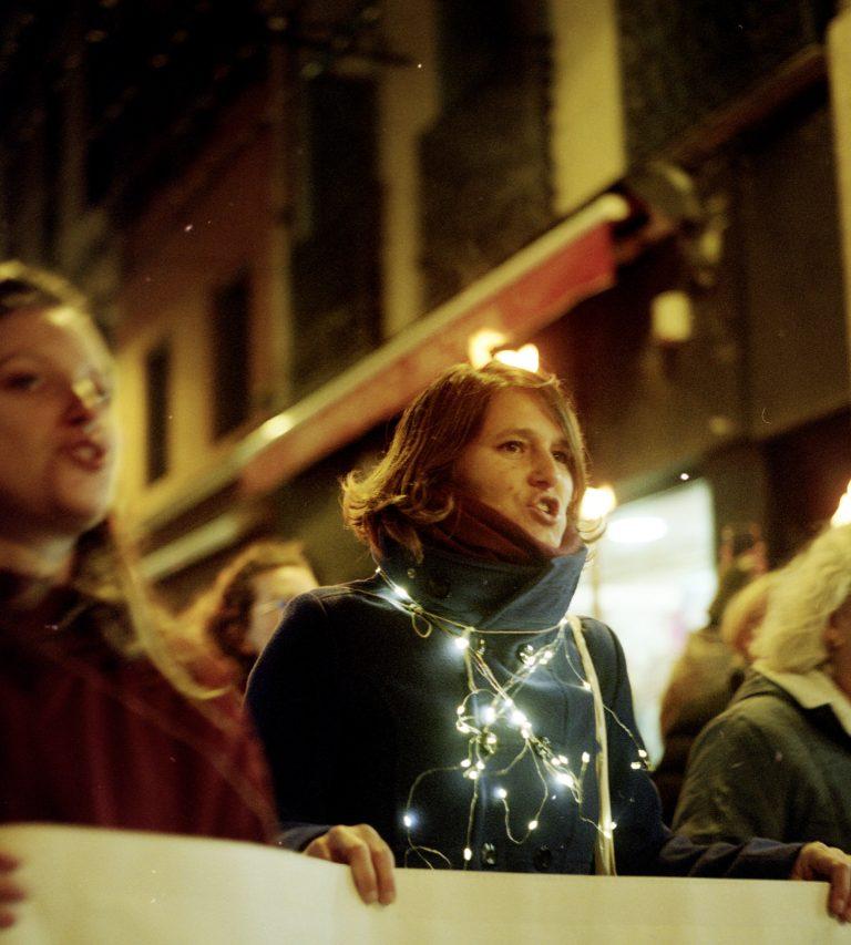 Manifestante tenant une banderole de tête dans la nuit
