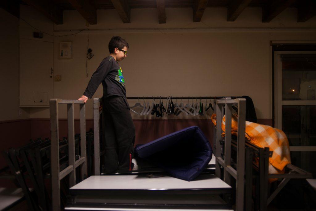 garçon debout sur un lit