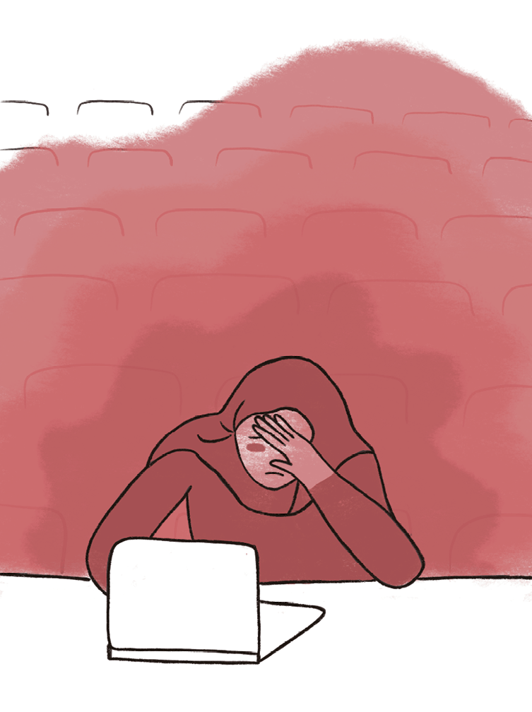étudiante voilée dans un amphi qui se met la main sur le visage et qui a l'air désespérée