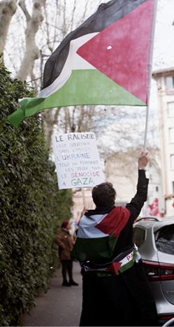 manif où quelqu'un tient un drapeau palestinien