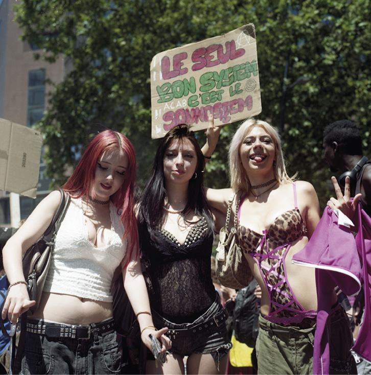 3 filles en manif pour les free party à Toulouse en juin 2026. Une porte une pancarte&nbsp;: "Le seul bon system, c'est le sound system"